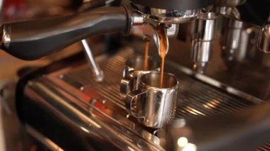 Hot fragrant coffee is poured in a thin stream into a mug, close-up