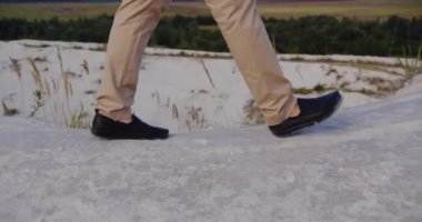 A man climbs a high steep rock