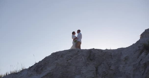 高い山の上に立っている間 花嫁は優しく彼女の新郎を抱きしめる 結婚式 — ストック動画