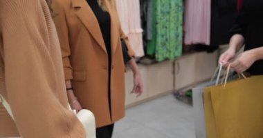 Girls leave the store with purchases. Shopping