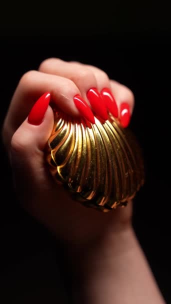 Ένα Γυναικείο Χέρι Κόκκινο Μανικιούρ Μαύρο Φόντο Κρατά Ένα Χρυσό — Αρχείο Βίντεο