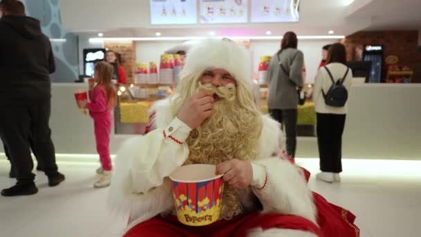 Санта Клаус Прийшов Кіно Їсть Солодкий Попкорн Розважаючи Відвідувачів — стокове відео