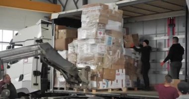 Bir forklift sürücüsü kargo konteynırını bir depoda karton kutularla taşıdığı için bir palet yüklüyor..