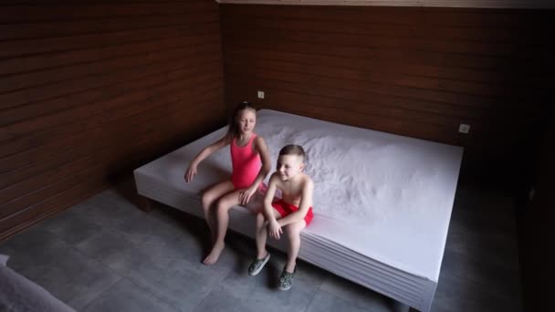 Lächelnde Jungen Und Mädchen Badeanzügen Liegen Auf Dem Bett Glückliche — Stockvideo