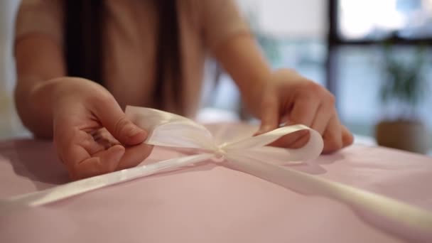 Una Donna Con Vestito Rosa Avvolge Una Confezione Regalo Lega — Video Stock