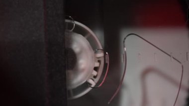 Bir videoda, bir kaset yerleştirilir ve içinde film olan davul döner, yakın plan. 4K