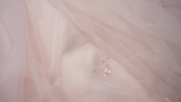 工作室里的一个女人用珠子缝上面纱来装饰婚纱的面料 她把珠子拿走了 — 图库视频影像