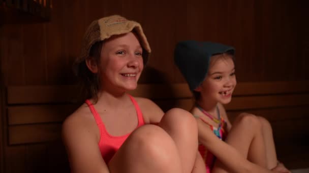Ευτυχισμένα Παιδιά Κάθονται Χαλαρά Μια Ξύλινη Σάουνα Φορώντας Μαγιό Και — Αρχείο Βίντεο