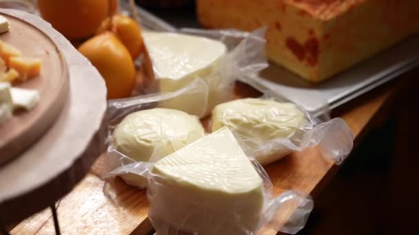Auf Dem Tisch Liegen Käse Verschiedener Sorten Vakuumverpackungen Und Scheiben — Stockvideo