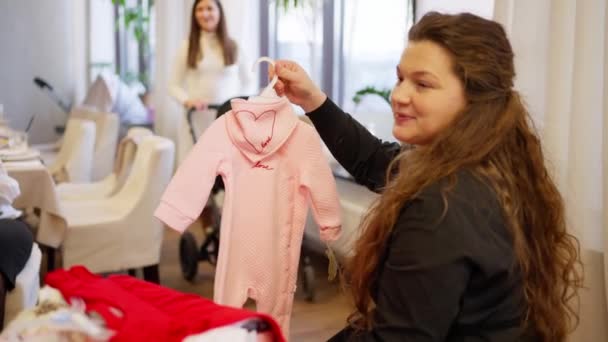 Kaukasisk Kvinna Väljer Kläder Barn Avdelning För Baby Hålla Små — Stockvideo