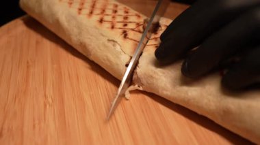 Biber, domates ve soslu leziz shawarma kompozisyonu içinde, ikiye bölünmüş..