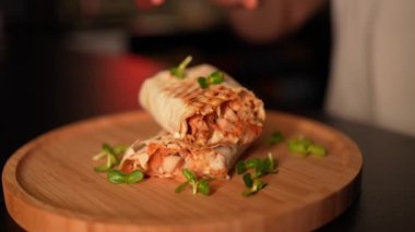 Kimliği belirsiz bir adam barda otururken donör kebabı yiyor.