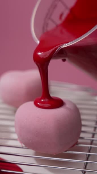 赤いクリームで覆われたハート型のデザートのクローズアップ おいしい甘いペストリーを屋内で調理する — ストック動画