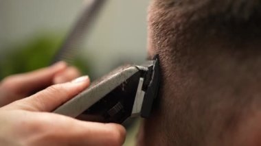 Modaya uygun bir kuafördeki adam. Kuaför bir erkek için şık bir saç stili yapar. Erkek saçına dikkat et.