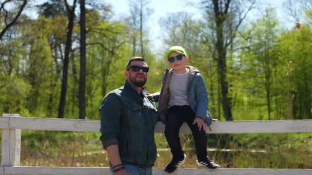 Papà Bambino Siedono Sulla Recinzione Nel Parco Guardare Bella Natura — Video Stock