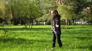 Ilık bir bahar gününde yeşil bir çayırda neşeyle sarılan iki kız kardeş.