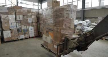 Depo, otomatik işlemler, yükleme ve boşaltma kutuları ve mallar, lojistik. Forklift kullanan biri depoda kutuları taşır.