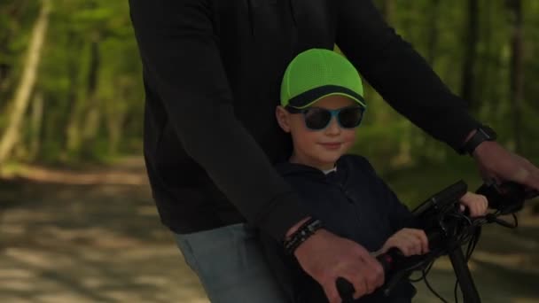 Joven Padre Monta Scooter Eléctrico Con Hijo Parque Cálido Día — Vídeo de stock
