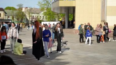 Bir genç, arka tekerdeki kalabalığın arasında bisiklet sürerken aşırı numaralar sergiliyor.
