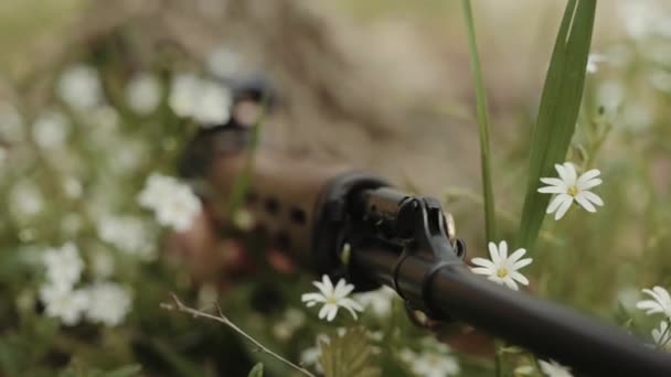 兵士は草の中に横たわって敵を撃つことを目指しています ウクライナ兵が森の中で戦っている 武器の再装填 — ストック動画