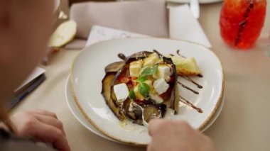 Restoranın şefinden bir tabak beyaz bir tabak, büyük bir tabakta kızarmış patlıcan, bir parça peynir ve sebze.