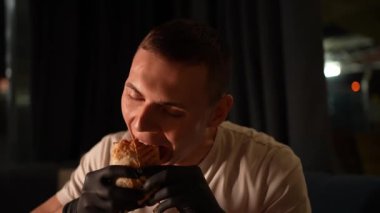Bir insan yemek yer ve zevk alır. Genç bir adam etli lezzetli bir pide ekmeğiyle mutlu olur. Fast food. Kapat.