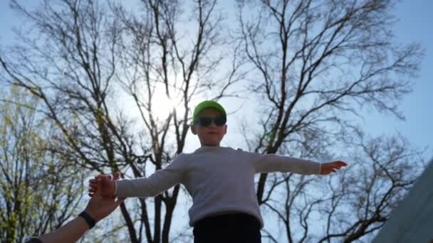 一个小男孩在公园里走在一根细长的横梁上的时候学会了保持平衡 克服了对高度的恐惧 一个勇敢的孩子勇敢地踩在地上的窄木板上 — 图库视频影像