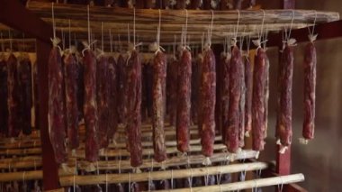 Lezzetli İtalyan usulü prosciutto tavandan sarkan tahta çubuklarda. Tuzlu ve aromalı Jamon