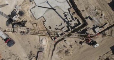 İnşaat alanına çimento dolu kovalarla beton dökerek..