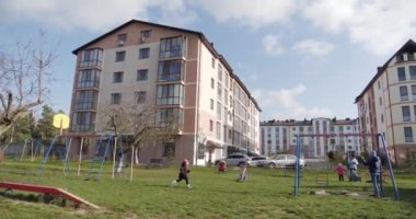 İlkokul çağındaki çocuklar ebeveynleriyle Central Park 'taki oyun parkında oynuyorlar. Salıncaklı ve çocuklu oyun parkı.