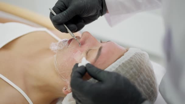 在灯下美容院里的女人 和美容师用特殊的喷头清洁面部皮肤 — 图库视频影像