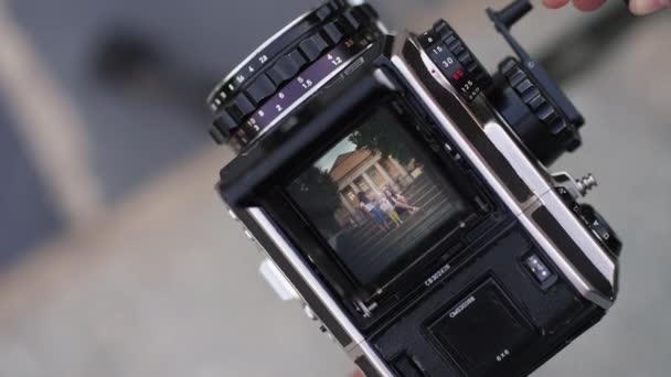 Bir Adam Elinde Eski Bir Kamera Tutuyor Poz Veren Insanların — Stok video