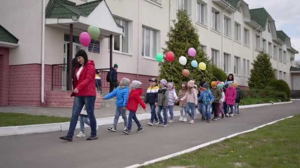 Eine Kindergärtnerin Geht Mit Kindern Auf Den Spielplatz — Stockvideo