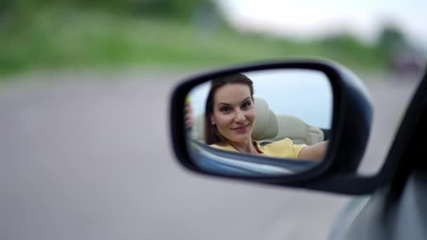 愛してる 鏡を見ている幸せな美しい女性は 彼女の反射で笑みを浮かべて 彼女の外観を楽しんで 高価な車の中で座って — ストック動画