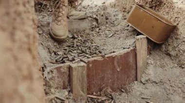 Kamuflajlı bir asker siperde durur ve ateş etmeye hazırlanır.