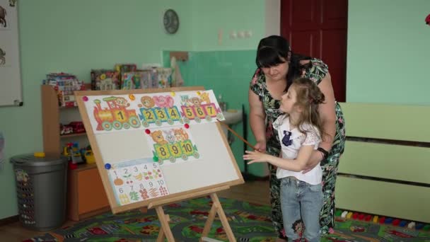 Eine Frau Kindergarten Zeigt Zahlen Mit Bildern Auf Der Tafel — Stockvideo