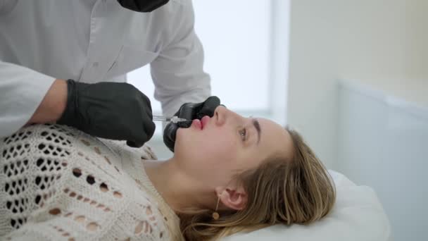 一个年轻的女人在嘴唇上注射肉毒杆菌素 一个女人在美容院里靠近点 — 图库视频影像