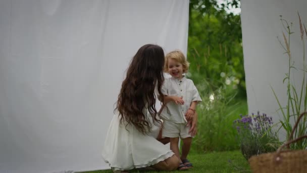 愛するコーカサス人の若い母親は夏の晴れた日に屋外でリラックスしながら愛らしい甘い赤ん坊を抱きます 母親と子供のテンダーの瞬間 — ストック動画