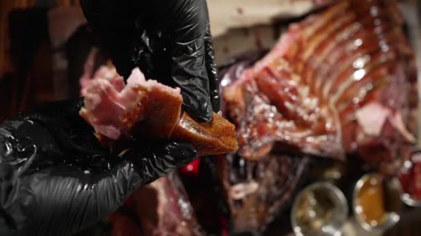 黒い手袋の男は脂肪質の豚肉の断片を涙し 彼の手で食べる — ストック動画