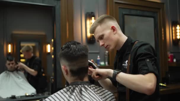 一个年轻人在理发店里用电剪理发 — 图库视频影像