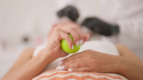 在医疗过程中 一名妇女为了减轻疼痛 多次用手捏住并释放绿球 — 图库视频影像