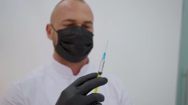医生手里拿着一个注射器 手里拿着药 戴着手套 脸上戴着防护面具 保健服务 — 图库视频影像