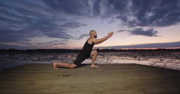 Bir Adam Mavi Gökyüzünün Batışında Nehir Kıyısında Yoga Yapıyor Doğada — Stok video
