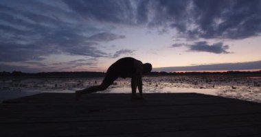 Bir atlet akşamları dışarıda yoga yapıyor.