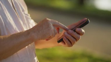İhtiyarların elleri cep telefonuna mesaj yazarken yakın plan çekimleri