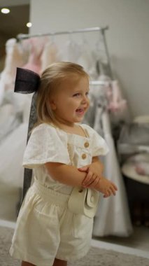 Beyaz giysiler içinde ve kafasında kurdeleyle gülümseyen küçük tatlı kız.