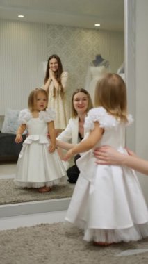 Danışman, bayram için müşteriler için elbise seçer.