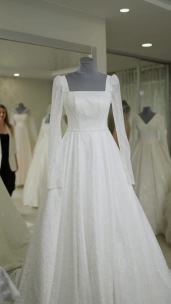 ファッションデザイナーはマネキンに白いウェディングドレスを置きます — ストック動画