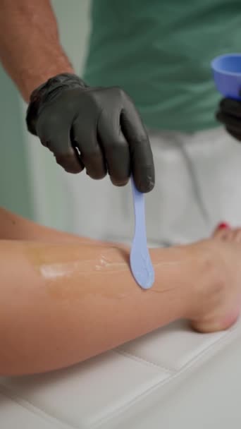 Ręka Kosmetologa Czarnych Rękawiczkach Lateksowych Nakłada Przezroczysty Żel Kobiecą Nogę — Wideo stockowe