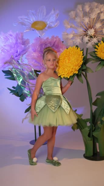 Mała Dziewczynka Zielonej Sukience Pozuje Tle Ściany Kwiatu Studio — Wideo stockowe